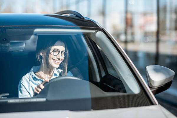 Happy woman driving a car